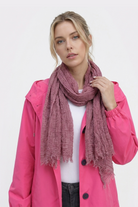 Wearing a bright pink jacket over a white shirt and the Lightweight Linen Scarf, a person stands against a plain white background, facing the camera with a neutral expression.