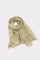 The Lightweight Linen Scarf in light beige is displayed on a white background, with one end rolled and the other spread out to show its frayed edges—an ultra-breathable, versatile accessory.