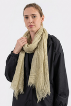 A person with light hair models the Lightweight Linen Scarf and a black jacket against a white background, facing the camera with a neutral expression—highlighting this stylish and versatile accessory.