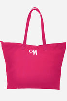 The Free Gift Urban Slate Waterproof bag is a large, bright pink duffel with smart organization, two handles, and a white embroidered "M" near the top center, shown against a plain white background.